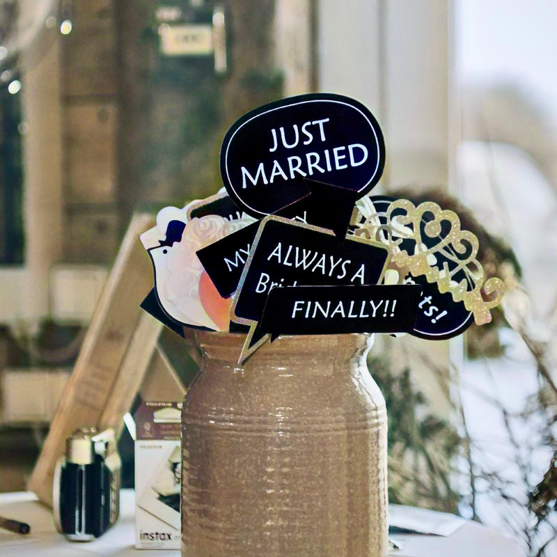 Bryllupsrekvisitter med Just married-skilte i en vase ved gæstebogen